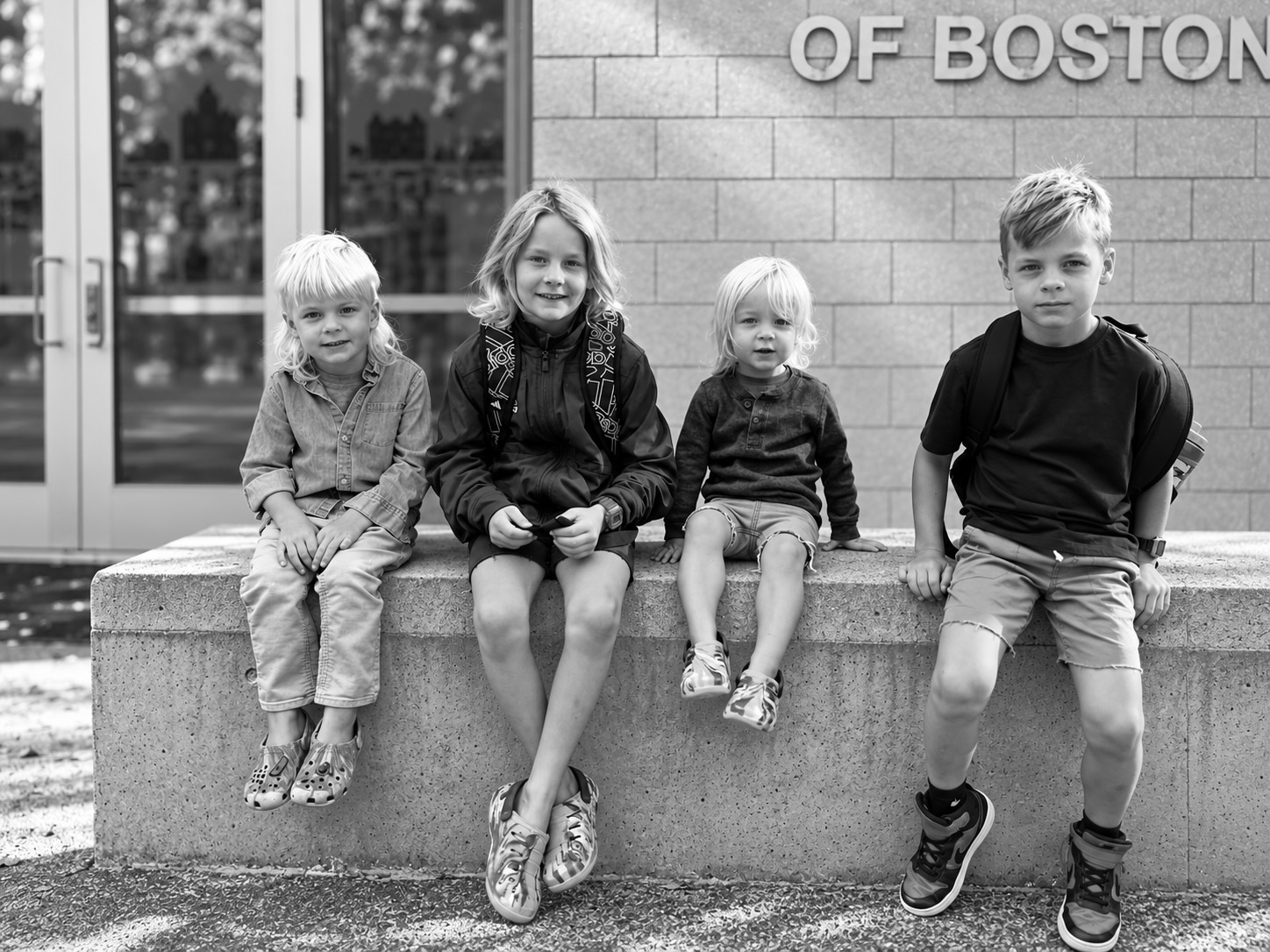 Silas, Jack, Cole and Anders sitting together on a stone ledge